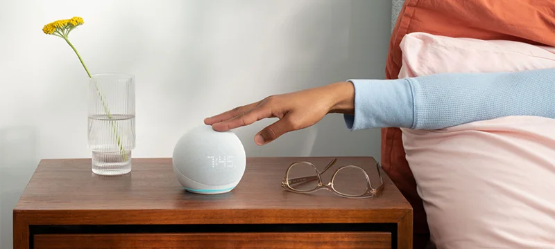 The Echo Dot with Clock on a bedside table.